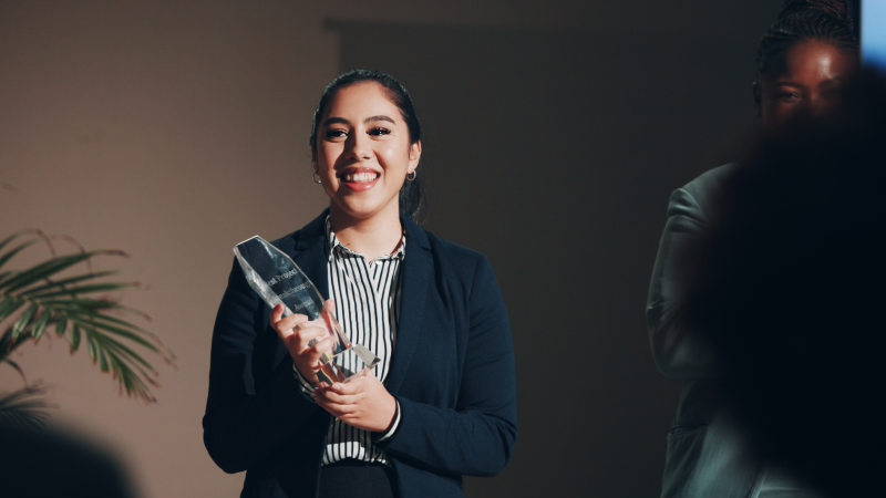 Young woman smiling while holding award