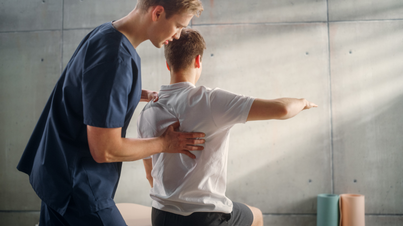 Physiotherapist working on patent's back muscles